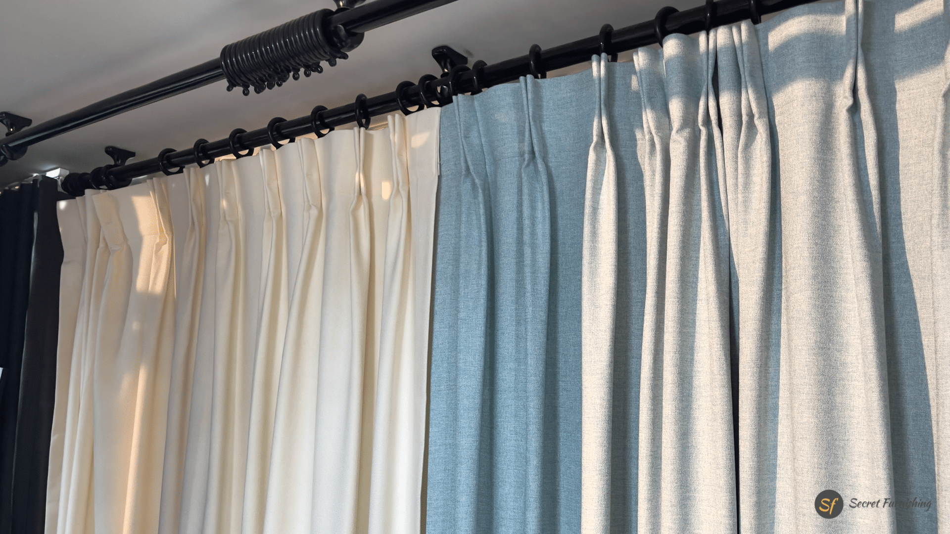three colored curtains installed on a curtain rod